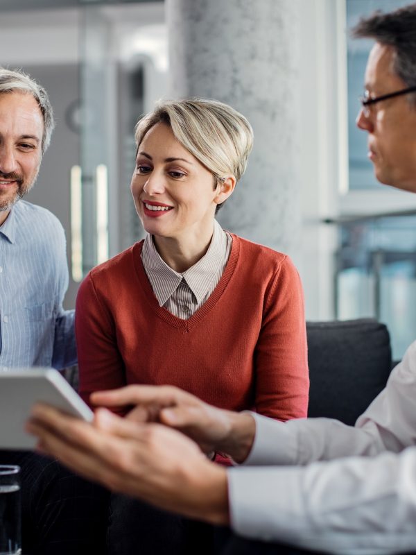 happy-mid-adult-couple-using-touchpad-with-their-financial-consultant-in-the-office-.jpg